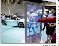  ?? AP/NG HAN GUAN ?? Visitors look at Buick’s Velite 5, a rebranded Chevrolet Volt, displayed Wednesday at the Auto Shanghai 2017 show at the National Exhibition and Convention Center.