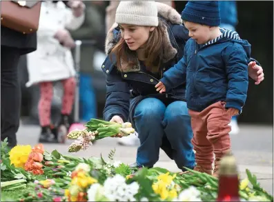  ??  ?? TOUCHING: A toddler is helped to lay flowers at Windsor Castle yesterday in honour of the Duke of Edinburgh