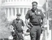  ?? PATRICK SEMANSKY/AP ?? U.S. Capitol Police officers stand guard Thursday at an intersecti­on near the U.S. Capitol and a Library of Congress building in Washington.