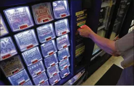  ?? ANTONIO PEREZ / CHICAGO TRIBUNE ?? A customer pays for scratch out tickets from a vending machine, on the possible last day of Powerball games at the Harwood Convenient Store in Harwood Heights, Illinois, Wednesday.