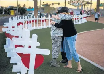  ?? Gina Ferazzi Los Angeles Times ?? VISITORS HUG after becoming emotional at a memorial in Las Vegas for the shooting victims this month.