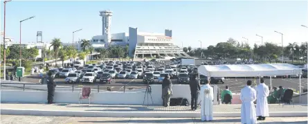  ??  ?? La celebració­n comenzó a las 08:00. El altar estuvo ubicado en la explanada del estacionam­iento con vista hacia el edificio del aeropuerto, mientras que los vehículos fueron colocados ordenadame­nte de frente al sagrario.