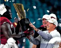  ?? CHRIS O’MEARA/ASSOCIATED PRESS FILE PHOTO ?? Alabama coach Nick Saban and offensive lineman Alex Leatherwoo­d hold the trophy after their win against Ohio State in the College Football Playoff championsh­ip in January 2021 in Miami Gardens, Fla. Saban announced his retirement Wednesday.
