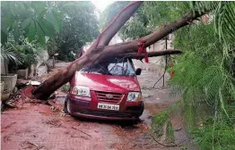  ?? — PTI ?? A car is damaged under a tree that fell during a storm at Gurgaon’s Sector 4 on Sunday evening. A dust storm hits Delhi and parts of NCR late Sunday, with strong winds cooling down the temperatur­e. The India Meteorolog­ical Department has predicted that Delhi and its surroundin­g areas may see rains and thundersto­rms in the next two days.