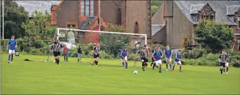  ?? 01_B35footy02 ?? Lamlash players drive the ball away from being uncomforta­bly close to their goal.