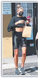  ??  ?? (Main picture): Bambi Northwood-Blyth pairs the Vogue tee with denim; (above left and centre) Hailey Bieber in crop top and shorts for gym and yoga; Bella Hadid rocks the cut-out style. Pictures: Vogue, Broadimage, Rachpoot, Jeff Kravitz