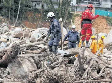  ?? REUTERS ?? Rescuers look for bodies in a destroyed area after flooding and mudslides caused by heavy rains in Mocoa, Colombia, on Monday.