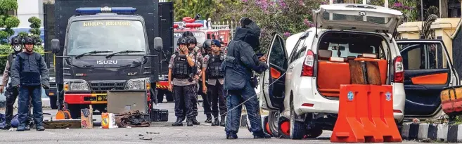  ?? DEFIZAL/RIAU POS/JPG ?? DIPATAHKAN: Tim Jihandak Gegana Satuan Brimob Polda Riau memeriksa mobil Avanza yang digunakan para teroris menyerang Markas Polda Riau kemarin. Empat teroris tewas dalam peristiwa itu.