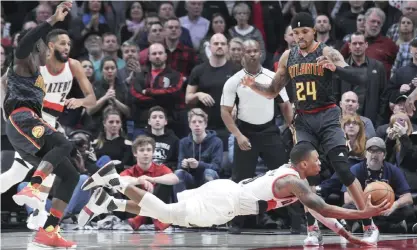  ??  ?? POETLAND: Portland Trail Blazers guard Damian Lillard falls to the court as he drives to the basket during overtime of an NBA basketball game against the Atlanta Hawksin Portland, Ore., Monday. Atlanta won in overtime 109-104. — AP