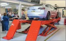  ?? EMILY OVERDORF — FOR MEDIANEWS GROUP ?? Scott Bentley’s Tesla was the first vehicle to be lifted on the Pottstown High School auto shop’s new Hawkeye Elite wheel alignment system, unveiled Thursday and paid for through donations.