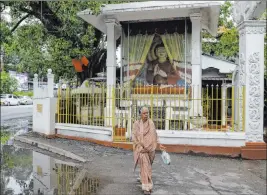  ?? Eranga Jayawarden­a The Associated Press ?? A Sri Lankan Muslim woman walks past a Buddhist shrine Thursday in Colombo, Sri Lanka. Catholic services were canceled for a second weekend in Sri Lanka’s capital.