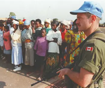 ?? RYAN REMIORZ / THE CANADIAN PRESS FILES ?? Numbers of Canadian peacekeepe­rs, such as this one watching a group of Rwandan refugees in 1994, are dwindling.