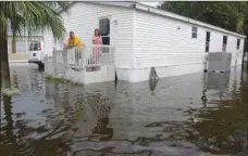  ??  ?? John and Cammie Harding look out onto flooded SW 5th St., in Sunshine Village on Wednesday in Davie, Fla. Several days of constant rain has caused flooding throughout Broward and Palm Beach counties. JOE CAVARETTA/SOUTH FLORIDA SUN-SENTINEL VIA AP