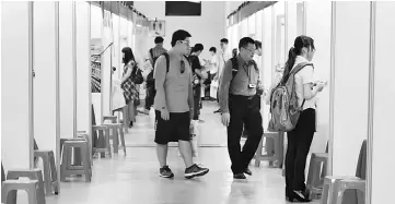  ??  ?? Photo shows visitors walking past recruitmen­t booths during a jobs fair in Taipei. Taiwan has long seen its internatio­nal allies switching allegiance to an ascendant Beijing, but now there are also fears of a brain drain of the island’s youth as they...