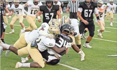  ?? Tim Godbee ?? Calhoun’s defenders Omarie Shoulders, Blaze Hamlett, and Christophe­r Lewis swarm a Ridgeland runner as part of a dominating 56-7 win last Friday night.