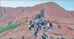  ?? AFP ?? A recent photo shows tourists climbing Uluru, also known as Ayers Rock, in Australia's Northern Territory.