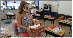  ?? (NWA Democrat-Gazette/David Gottschalk) ?? Rhonda Walton, a first-grade teacher at Asbell Elementary School in Fayettevil­le, sets out supplies
Wednesday.