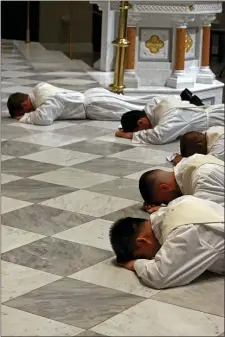  ?? STUART CAHILL — BOSTON HERALD ?? The new priests lay on the alter as Cardinal O’Malley ordains five new priests at the Cathedral of the Holy Cross on Saturday.