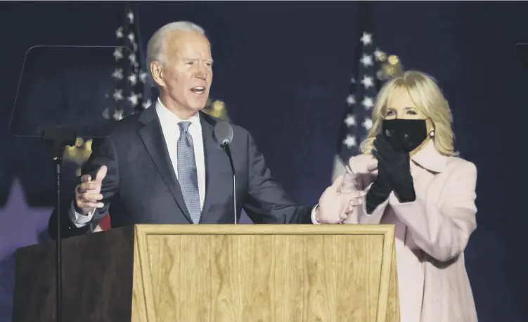  ??  ?? 0 Democratic presidenti­al nominee Joe Biden speaks at a drive- in election night event as Dr. Jill Biden looks on at the Chase Center in Wilmington, Delaware