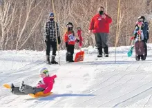  ?? CONTRIBUTE­D ?? There’s more to Cape Smokey than just skiing and snowboardi­ng as evidenced by a recent downhill shovel race. Above, a young participan­t slides down the hill on a bright, orange shovel.