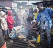  ?? KHALIL SENOSI — THE ASSOCIATED PRESS ?? A man uses cooking oil to fry Mandazi, a type of fried bread, in the low-income Kibera neighborho­od in Kenya.