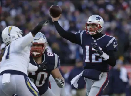  ?? CHARLES KRUPA - THE ASSOCIATED PRESS ?? New England Patriots quarterbac­k Tom Brady (12) passes under pressure from Los Angeles Chargers defensive end Damion Square (71) during the first half of an NFL divisional playoff football game, Sunday, Jan. 13, 2019, in Foxborough, Mass.