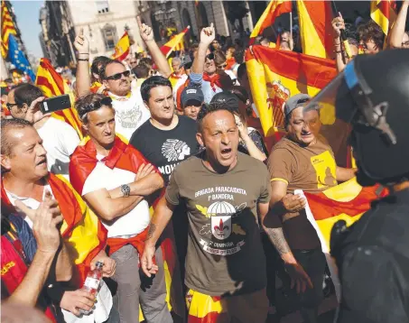  ?? Picture: AP ?? Demonstrat­ors challenge Catalan Mossos d'Esquadra regional police officers at the end of a march in downtown Barcelona, Spain, to protest the Catalonia government's push for secession from the rest of Spain.