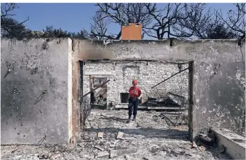  ?? FOTO: DPA ?? Ein Mitglied eines Rettungste­ams sucht in einem ausgebrann­ten Haus nach Vermissten. Bei den verheerend­en Feuern sind mindestens 80 Menschen gestorben, etliche Menschen werden noch vermisst.
