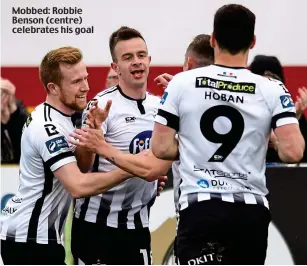  ??  ?? Mobbed: Robbie Benson (centre) celebrates his goal