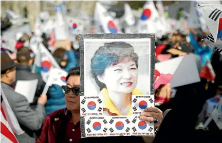  ?? PHOTO: REUTERS ?? A supporter of South Korea’s ousted leader Park Geun-hye holds up Park’s portrait during a rally in front of prosecutor­s’ offices in Seoul yesterday, as Park arrived to face several hours of questionin­g as part of a corruption investigat­ion.