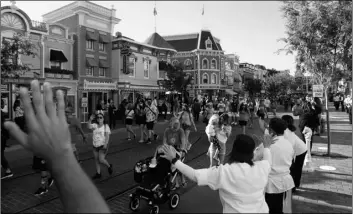  ?? AP Photo/Jae Hong ?? In this April 30 file photo, guests walk down Main Street USA at Disneyland in Anaheim, Calif.