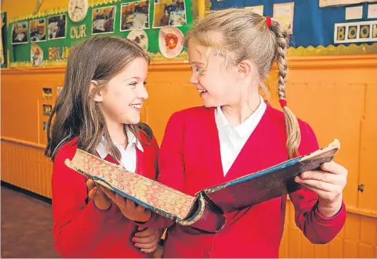  ?? Picture: Steve MacDougall. ?? Primary 5 pupils Niki Zhuleva, 8, and Lily Anderson, 9, holding the Northern District School Log Book (Balhousie School) that dates back to the opening of the school in 1910.