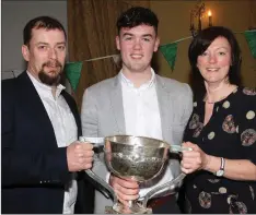  ??  ?? Quinn Saunders with his parents, Michael and Nicola, at the medals presentati­on to the Leinster-winning St. Peter’s College footballer­s.