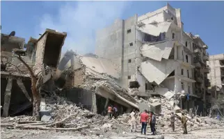  ??  ?? TARGETED: Men inspect a damaged site after double airstrikes on the Bab Al-Nairab neighborho­od of Aleppo, Syria, on Saturday. (Reuters)