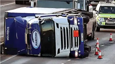 ??  ?? Traffic-stopper: Long queues formed after this lorry blew over on the M11