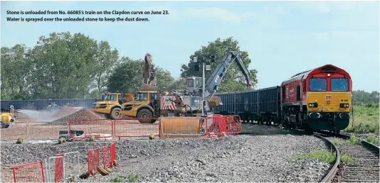  ??  ?? Stone is unloaded from No. 66085’s train on the Claydon curve on June 23. Water is sprayed over the unloaded stone to keep the dust down.