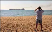  ?? PTI ?? A man takes a picture as the Glory bulk carrier makes its way from the port in Odesa, Ukraine, Sunday