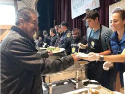  ?? AP Photo/ Kathleen Ronayne ?? ■ Eduardo Garcia, left, is served a warm meal during a community Thanksgivi­ng celebratio­n at California State University­Chico in Chico, Calif. Garcia lost his home in the Paradise wildfire, and his immediate family lives in Hawaii.