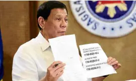  ?? —MALACAÑANG­PHOTO ?? FAKE ACCOUNT President Duterte shows on state television a document bearing the fictitious bank account number that he earlier claimed was owned by Sen. Antonio Trillanes IV.