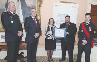  ??  ?? Paolo Fongemie a reçu son prix du CLFC de Jocelyne Roy-Vienneau, lieutenant­e-gouverneur­e du Nouveau-Brunswick, en présence du sergent Shawn Gauvin.