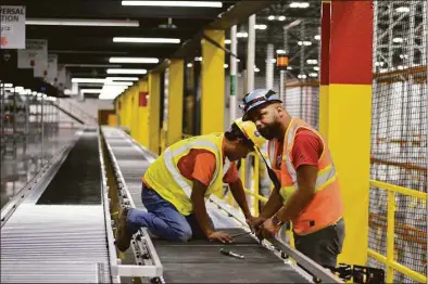  ?? Clare Dignan / Hearst Connecticu­t Media file photo ?? Workers at Amazon’s North Haven fulfillmen­t center.