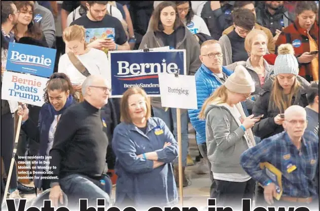  ??  ?? Iowa residents jam caucus site in Des Moines on Monday to select a Democratic nominee for president.