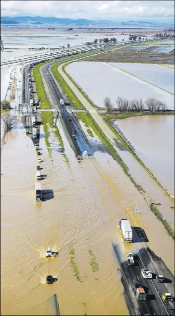 ?? RANDY PENCH/THE SACRAMENTO BEE VIA AP ?? Traffic on Interstate 5 at Williams, Calif., is slowed by standing water Saturday. Northern California and the San Francisco Bay Area were facing a weekend return of heavy rain and winds from an atmospheri­c river of moisture.