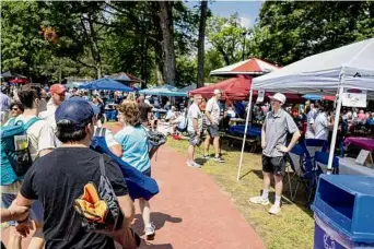  ?? ?? Griffen Miller stands with his canopy at the Saratoga Race Course on Saturday. Popular locations for canopy setups include those overlookin­g the paddock or the race track.