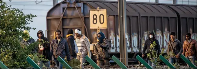  ??  ?? Breakthrou­gh: Migrants who made it past the Channel Tunnel security fences at Calais head for the tunnel entrance to try to board a train to Britain