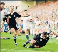  ??  ?? THE CHARGE OF IMMOVABLE FORCE: Top, Jonah Lomu of New Zealand dives over for the try during the 1995 Rugby World Cup match against England in Cape Town. New Zealand beat England 45-29. Right: England’s Tim Rodber tries to stop Lomu in the second rugby...