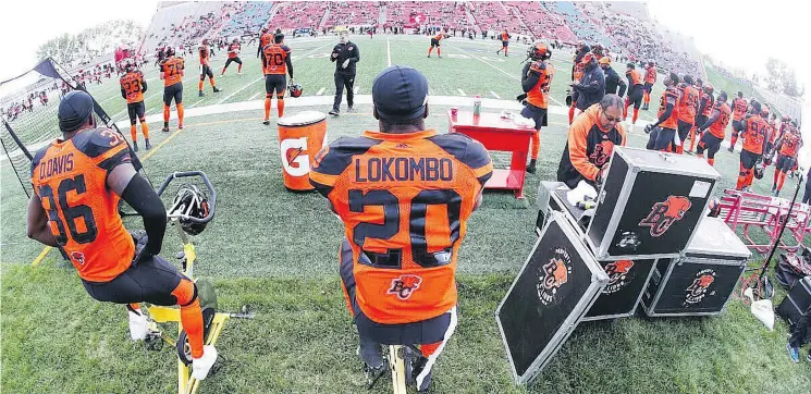  ?? — B.C. LIONS PHOTO ?? Lions linebacker­s Dyshawn Davis and Bo Lokombo keep loose on stationary bikes during a pre-season game in Calgary on Friday.