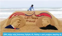  ?? — AFP ?? PURI: Indian artist Sudarshan Pattnaik, 65, finishes a sand sculpture depicting US President Donald Trump and North Korean leader Kim Jong Un at Puri beach, ahead of the US-North Korea summit.