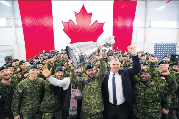  ?? JONATHAN HAYWARD/THE CANADIAN PRESS ?? Cpl. Cody Williamson of Smithers, B.C., hoists the Grey Cup alongside CFL commission­er Randy Ambrosie on Tuesday at CFB Edmonton.