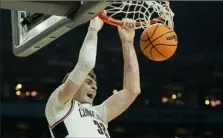  ?? David J. Phillip/Associated Press ?? Connecticu­t center Donovan Clingan dunks against Alabama during the second half of a Final Four game Saturday in Glendale, Ariz.